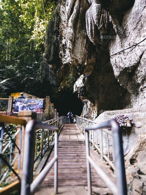 Gua Kelam Recreational Park, as known as dark cave entrance with tourists. Stock Photo by ellinnur