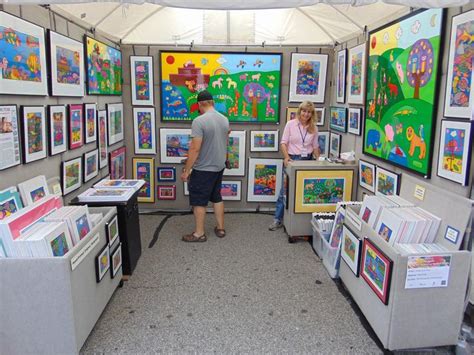 two people looking at art on display in a tent