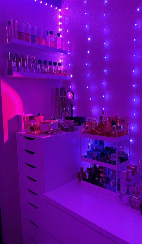 the room is lit up with purple lights and various bottles on shelves ...
