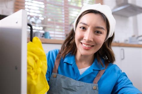 Premium Photo | Smiling young woman in apron and cleaning gloves open ...