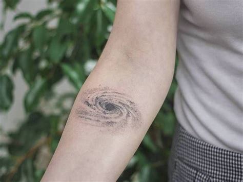 a woman's arm with a tattoo on it that has a swirl in the middle