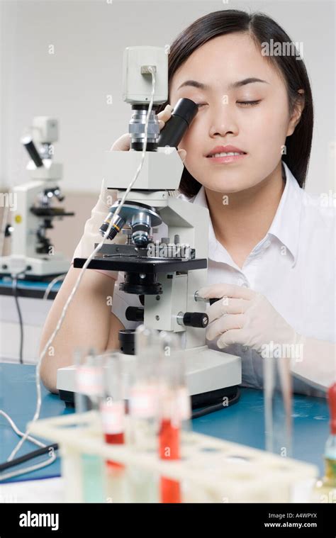 Female student using a microscope Stock Photo - Alamy