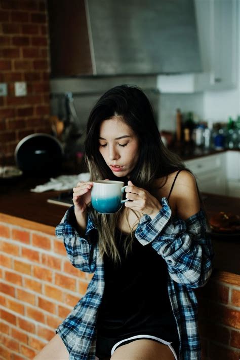 Girl drinking coffee in kitchen - Sinouk Coffee