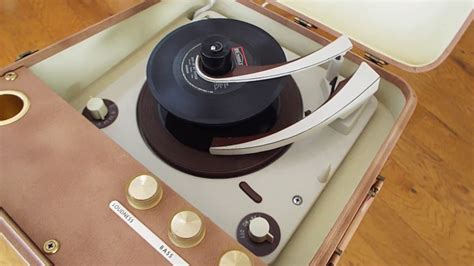 Magnavox portable record player playing a stack of 45 RPM records ...