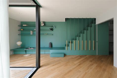 a room with wooden floors, green walls and shelves on either side of the wall