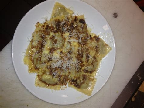 a white plate topped with pasta covered in grated cheese on top of a table