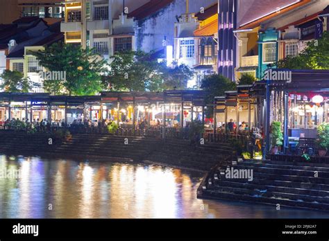 A night view of the Boat Quay on the Singapore River in Singapore. The busy and popular tourist ...