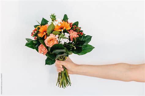 "Woman's Hand Holding A Bouquet Of Flowers." by Stocksy Contributor "HIGHLANDER" - Stocksy