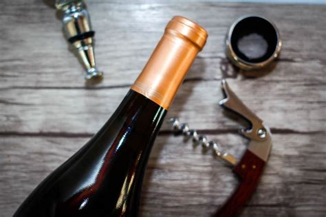 Wine bottle with a wine opener on a wooden background - Creative Commons Bilder