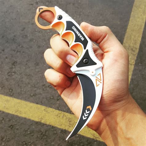 a hand holding a multi - tool in the middle of a parking lot with no one around it