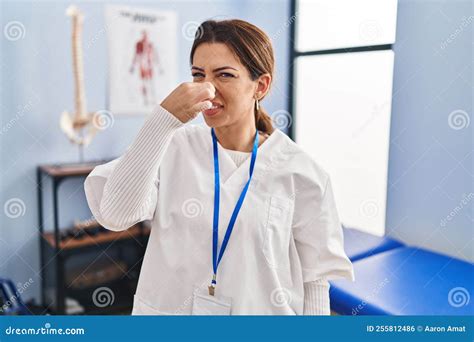 Young Brunette Woman Working at Pain Recovery Clinic Smelling Something ...