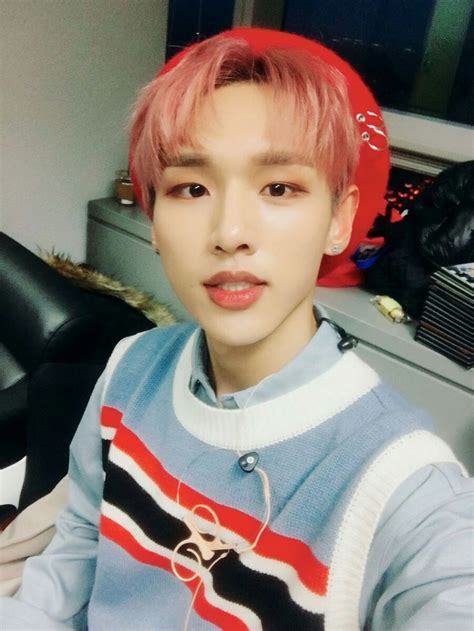 a young man with pink hair wearing a blue sweater and red headband ...