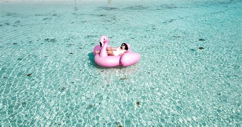 Woman Lying on Pink Flamingo Bouy on Body of Water · Free Stock Photo