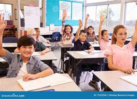 Elementary School Kids in a Classroom Raising Their Hands Stock Photo ...