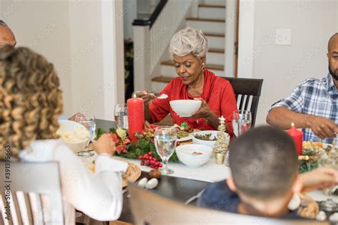 Black family eating Christmas dinner together at dining room table ...