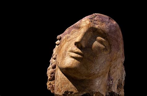 a carved head is shown against a black background