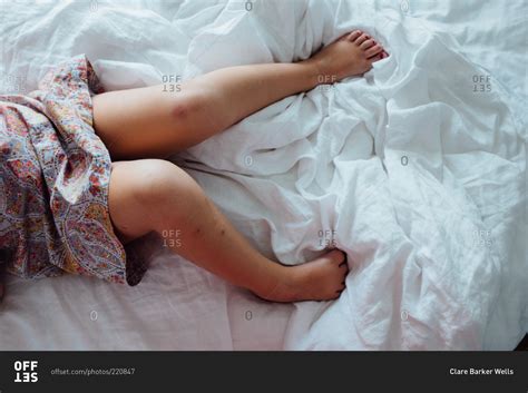 Little girl lying in bed stock photo - OFFSET