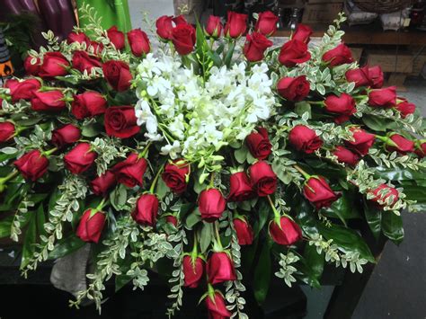 Casket spray with heart in center made of dendrobium orchids finished off with red roses ...