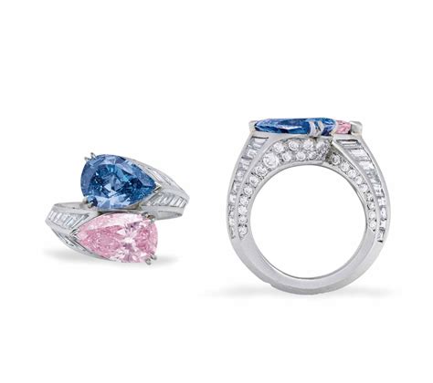 AN EXCEPTIONAL TWIN-STONE COLORED DIAMOND & DIAMOND RING, BY CARTIER. Of crossover design, set ...