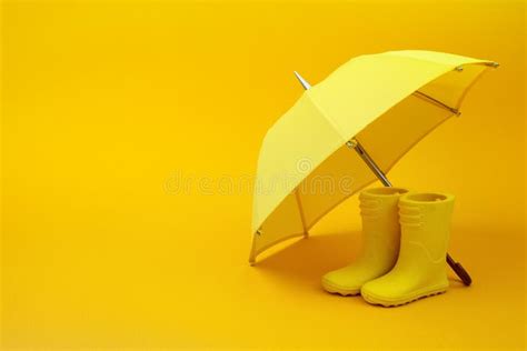 A Pair of Yellow Rain Boots and a Umbrella on a Yellow Stock Image ...