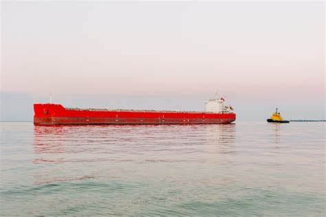 Premium Photo | A red cargo ship is sailing on the sea