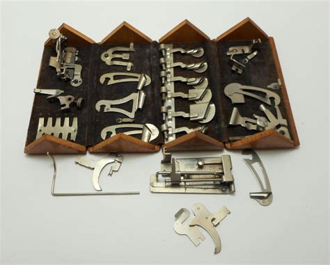 an assortment of metal tools in a wooden box