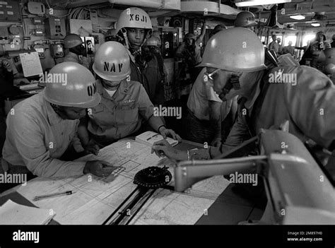 Crew members participate in a general quarters drill on the bridge of the submarine tender USS ...