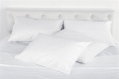 Premium Photo | White pillows on bed in room