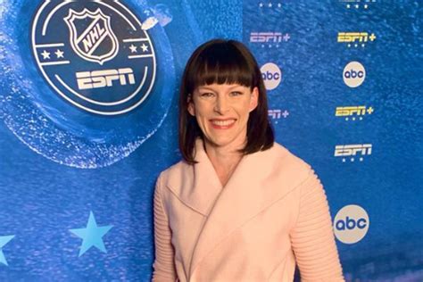 a woman standing in front of a blue wall with the logo of an ice hockey ...