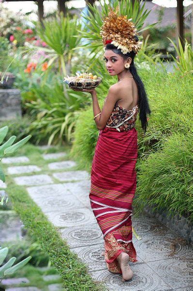 A group of traditional balinesse woman lifted the bundle of fruits in their head up (indeed one ...