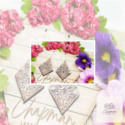 the earrings are made from metal and have pink flowers on them, along with purple pansies