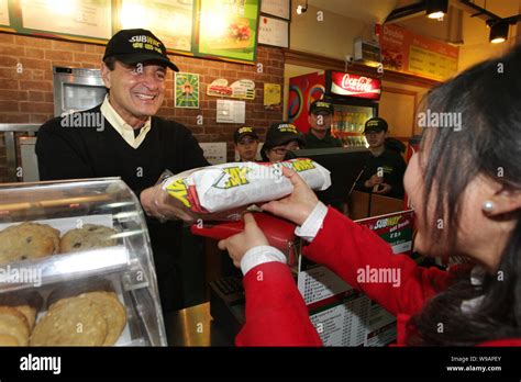 Fred DeLuca, President of Subway, serves a customer at a Subway restaurant in Shanghai, China ...