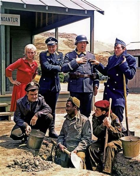 a group of people standing around each other holding shovels and buckets in front of a building