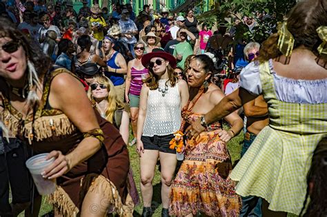 a group of people standing around each other in the grass at a music ...