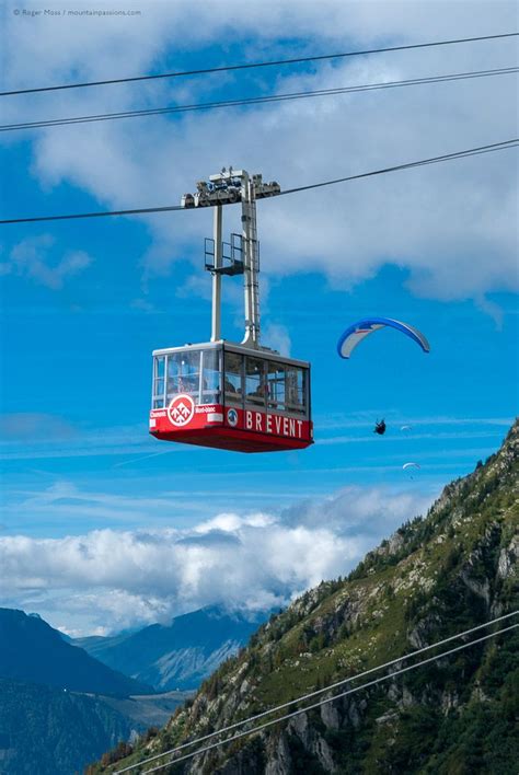 a red and white cable car going up the side of a mountain