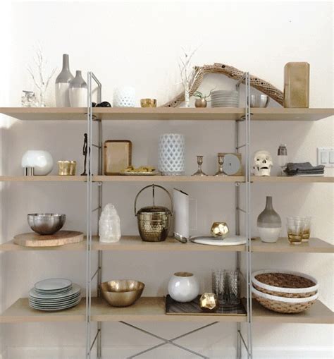 a shelf filled with lots of different types of dishes and vases on top ...