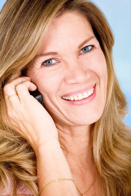 senior woman smiling on the phone over a blue background | Freestock photos