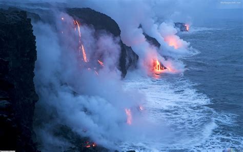 lava flowing into the ocean with red and yellow lights coming from it's cliffs