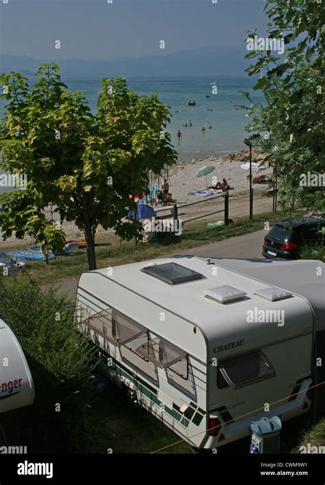 Caravan parked beside the beach at Lake Garda, Camping Lido, Pacengo, Italy, on a hot summer's ...