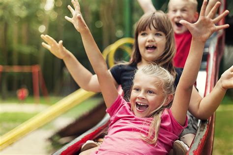 Happy kids playing on slide - Sproutlings Childcare