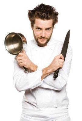 a man with a beard holding two large metal pans in one hand and a knife ...