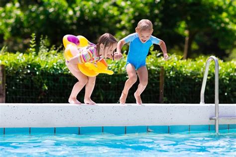 Kids jumping into swimming pool Stock Photo by ©FamVeldman 117417542