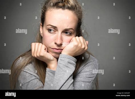 Young woman close up sad face resting on hands looking hopeless in to the distance concept Stock ...