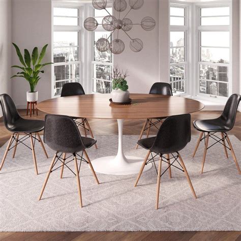 a dining room table with black chairs and a white rug on the floor in front of large windows