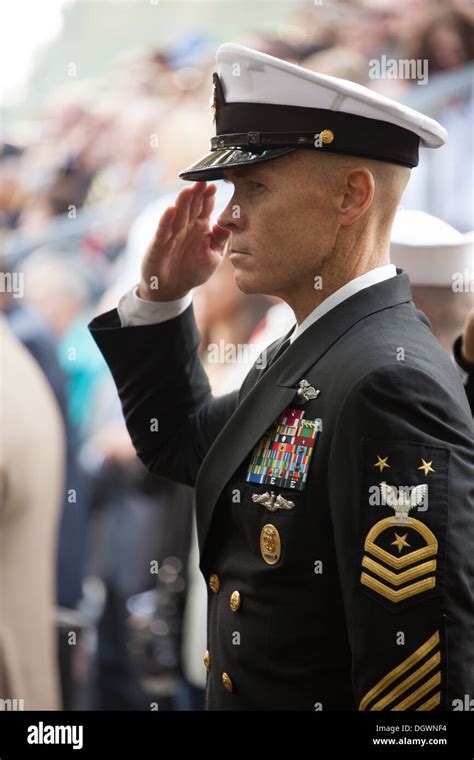 A U.S. Navy Master Chief Petty Officer salutes during the national ...