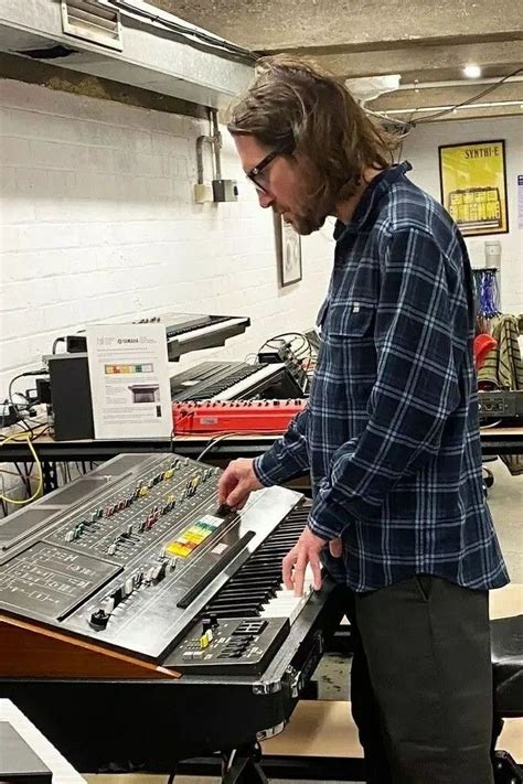 a man standing in front of an electronic keyboard