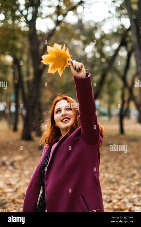 Autumn fashion, earth tones style, bright fall color palette. Portrait of red-haired girl in ...