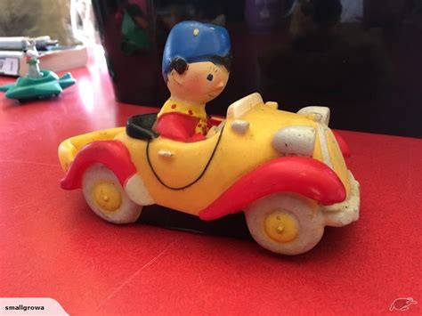 a yellow toy car with a blue helmet on it sitting on a red counter top