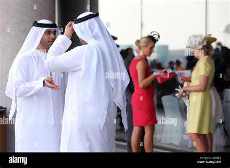 Dubai, United Arab Emirates, men in national dress and elegantly dressed women Stock Photo - Alamy