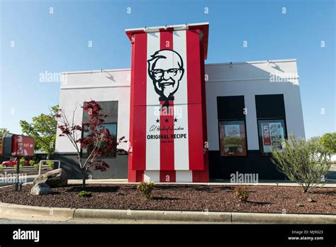 A logo sign outside of a KFC (Kentucky Fried Chicken) fast food ...